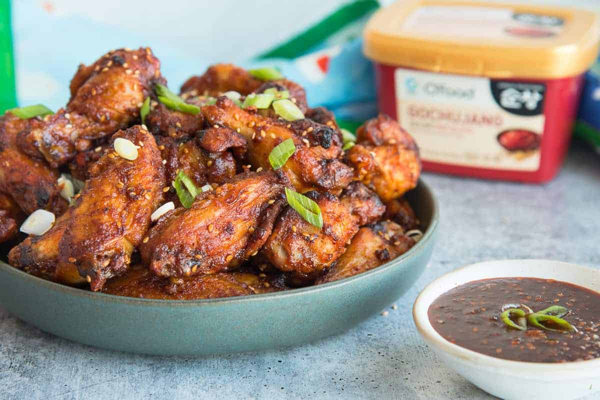 Horizontal image of a green bowl filled with Gochujang Air Fryer Chicken Wings