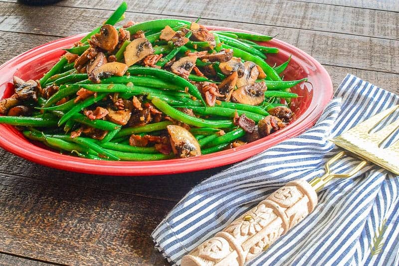 A red plate with Haricot Verts with Bacon and Portobellos