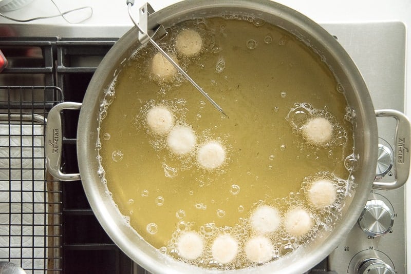 Donut holes frying in a pan of oil