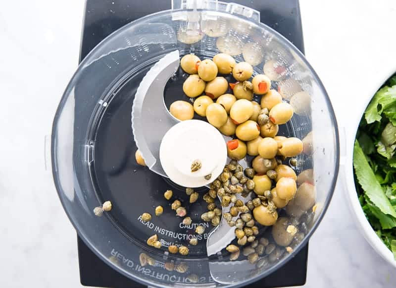 Olives and capers are pureed in the food processor