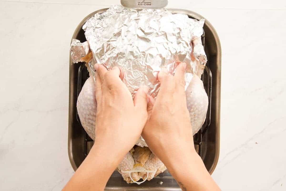 A foil covering is placed on the turkey breast before roasting.