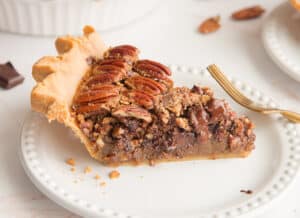 Preview image of a slice of Maple Bourbon Pecan Pie with Chocolate Chunks on a white plate.