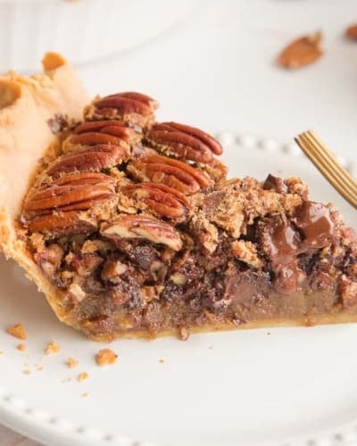 Preview image of a slice of Maple Bourbon Pecan Pie with Chocolate Chunks on a white plate.