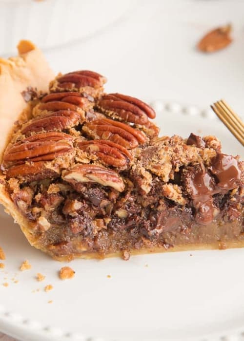 Preview image of a slice of Maple Bourbon Pecan Pie with Chocolate Chunks on a white plate.