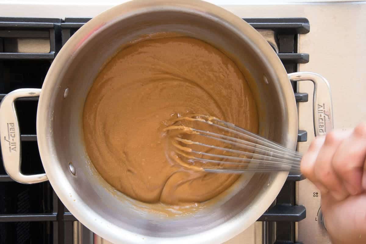 The brown sugar and butter mixture have a taffy-like consistency in the pot.