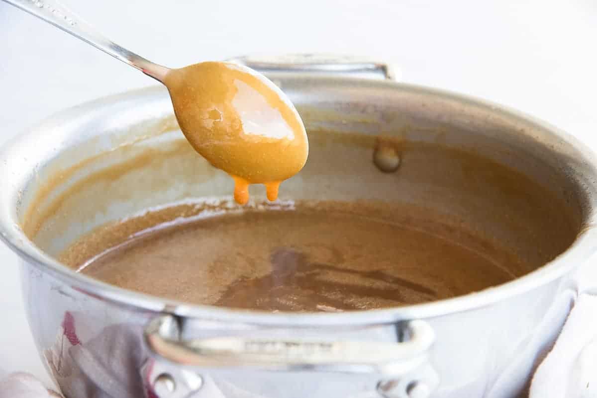 The sauce drips quickly from a spoon when lifted from the pot.