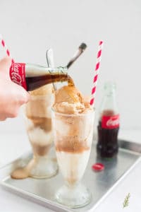 Pouring Coke onto scoops of vanilla frozen custard