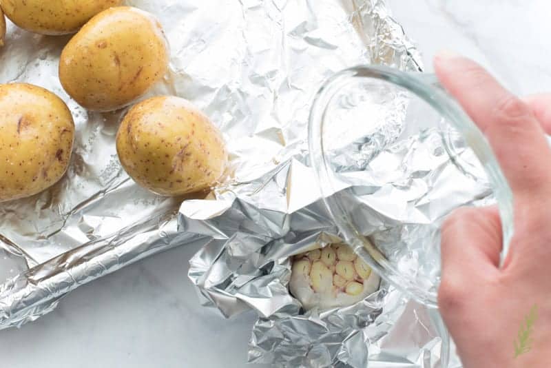 Oiled is added to a garlic bulb wrapped in foil