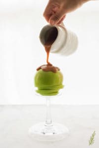 Salted Vanilla Caramel Sauce is poured over a green apple