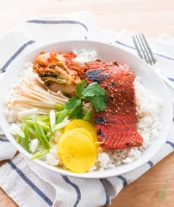 A white bowl is filled with white rice and Miso-Ginger Salmon
