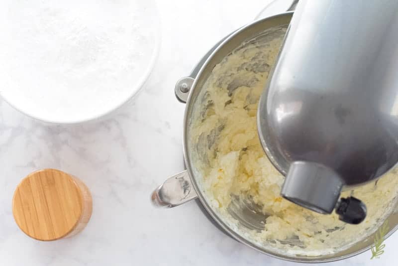Butter and sugar and salt are mixed together in a silver stand mixer
