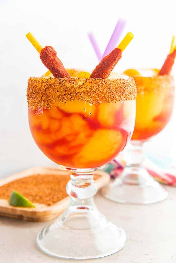 Lead image of Mangonadas Margaritas in schooner glasses garnished with tamarind chile straws