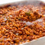Scooping a spoonful of Texas Baked Beans out of the pan
