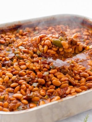 Scooping a spoonful of Texas Baked Beans out of the pan