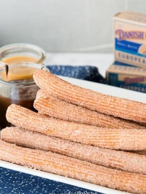 A plate of Churros with Dessert Dipping Sauces on the side
