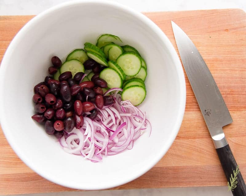 Overhead shot of the olives, cucumber, and red onion in a bowl