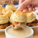 Dipping a skewer with chicken and biscuit into the maple-butter dipping sauce