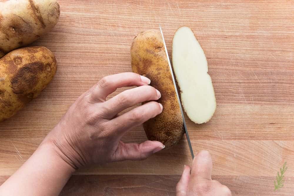 Slicing the russet potato provides a solid base for cutting
