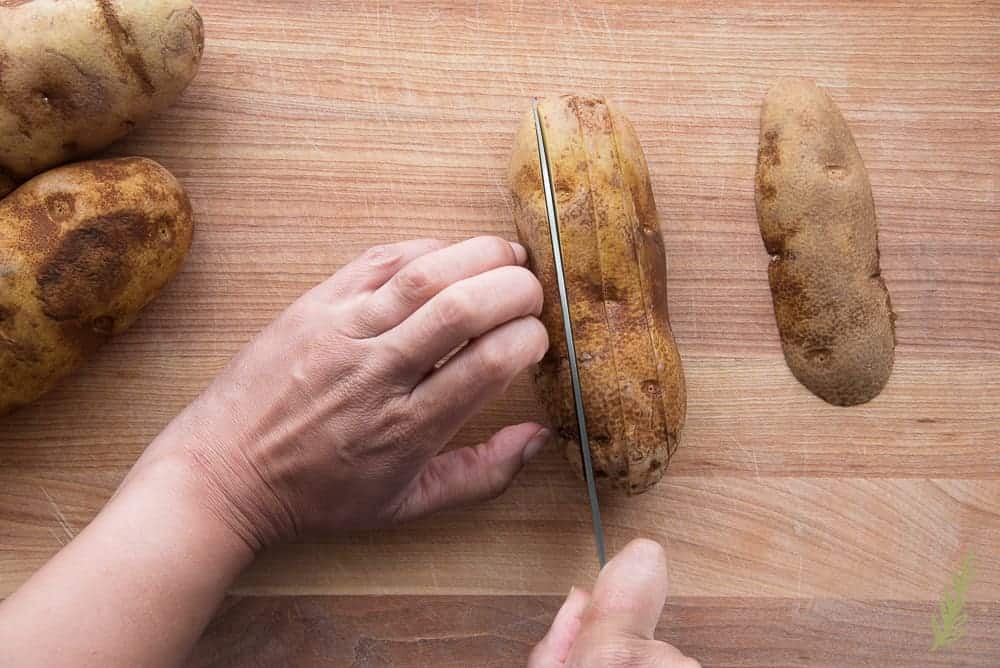 Cutting the potato into 1/4"-1/2" thick slices