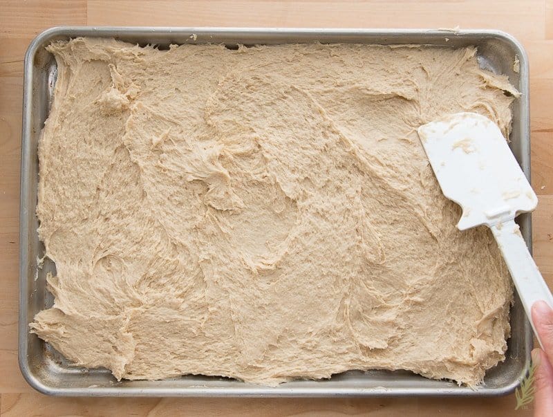 Spread the bread dough onto a greased sheet pan before chilling