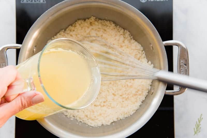 Pour the chicken broth into the sauteed grits