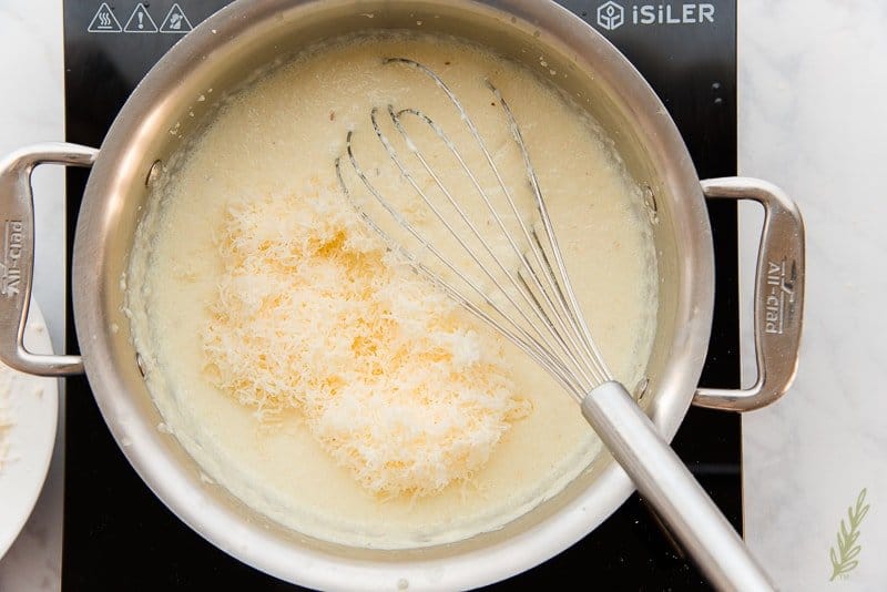 Add the finely shredded cheddar cheese to the garlicky grits