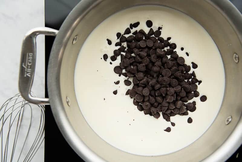 Chocolate chips are added to the hot cream before being stirred in to make the chocolate ganache