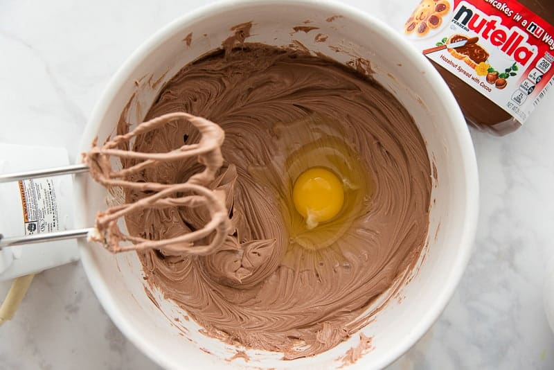 Add the eggs to the cheesecake batter, one at a time