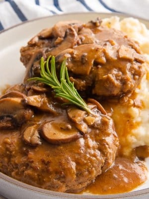 A close up of the Salisbury Steak with a sprig of thyme on top