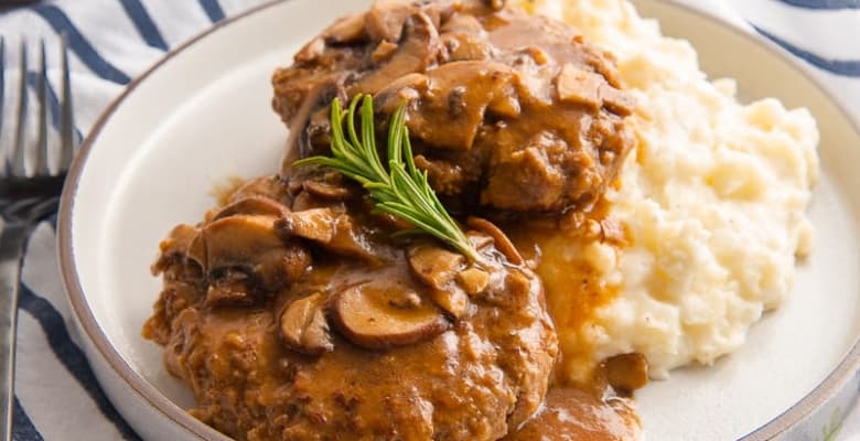 A close up of the Salisbury Steak with a sprig of thyme on top