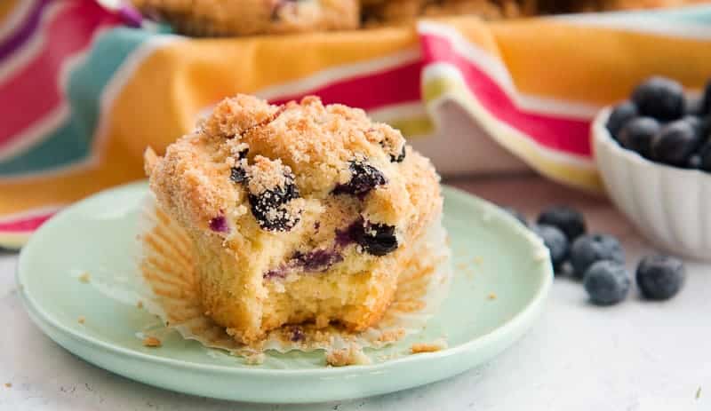 A bite taken out of a single Blueberry-Almond Streusel Muffin