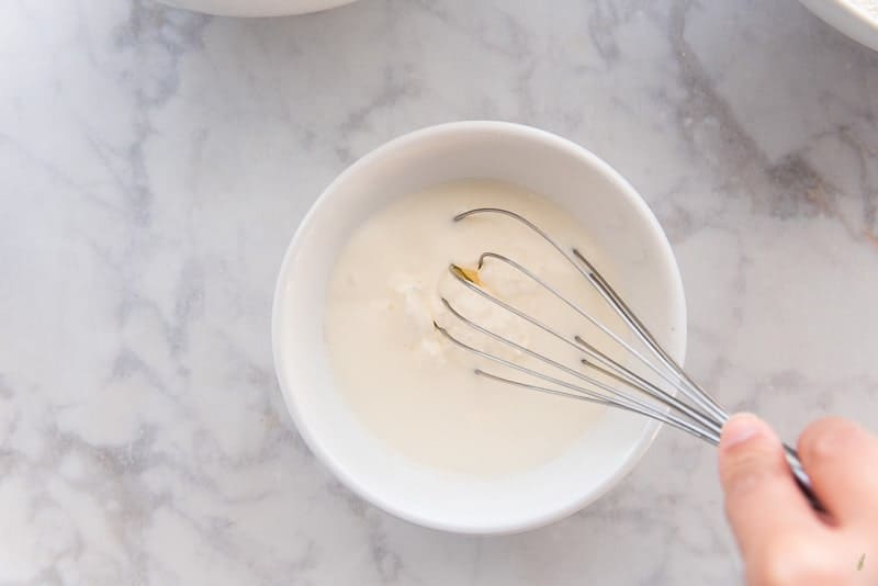A whisk is used to combine the wet ingredients in a small mixing bowl. 