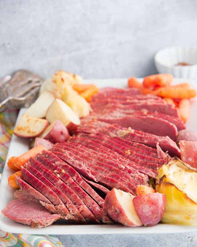 The Corned Beef and Cabbage is arranged on a white platter