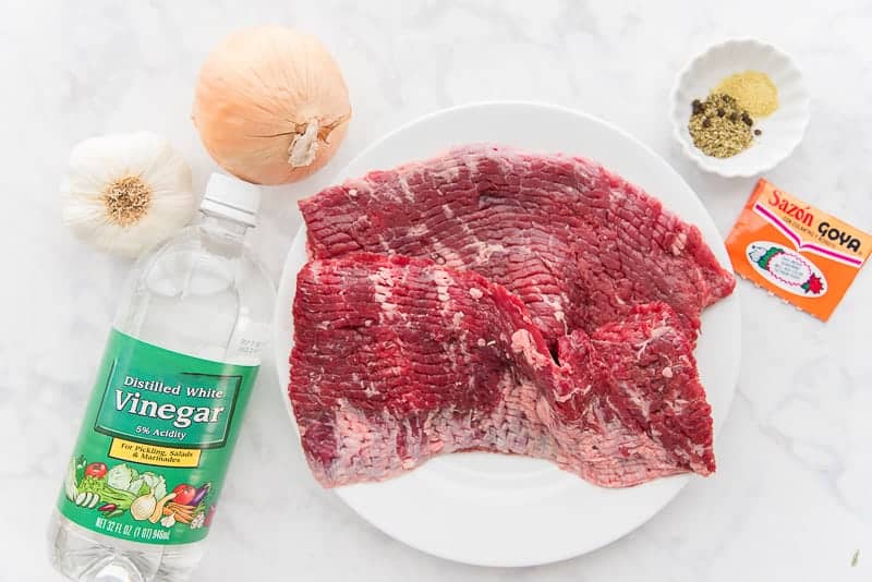 The ingredients for Bistec Encebollao beef, spices, vinegar, onion, garlic