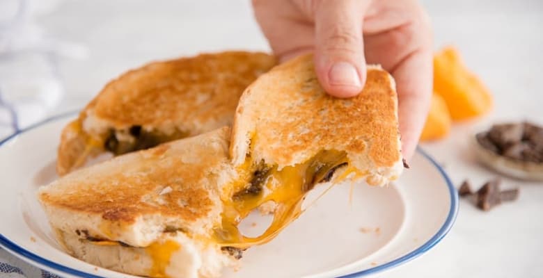 An epic cheese pull from the Grilled Cheese and Chocolate Sandwich