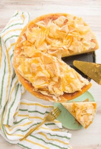 An overhead portrait of a cut Honey Cheesecake with Baklava Crust