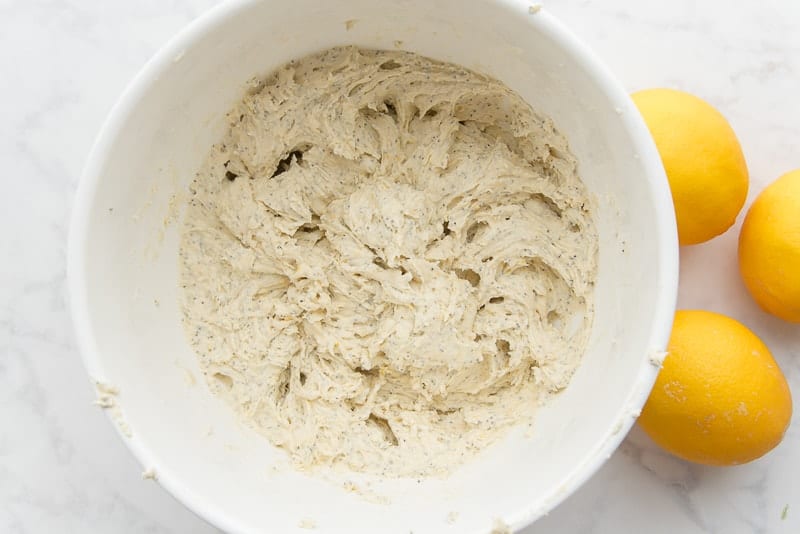 The mixed lemon poppy seed muffin batter in a white bowl