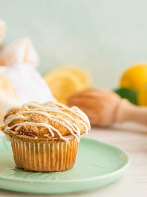 A landscape image of a single Lemon Poppy Seed Muffin on a mint green plate.