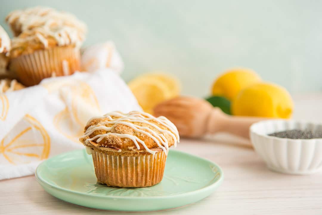 A landscape image of a single Lemon Poppy Seed Muffin on a mint green plate.
