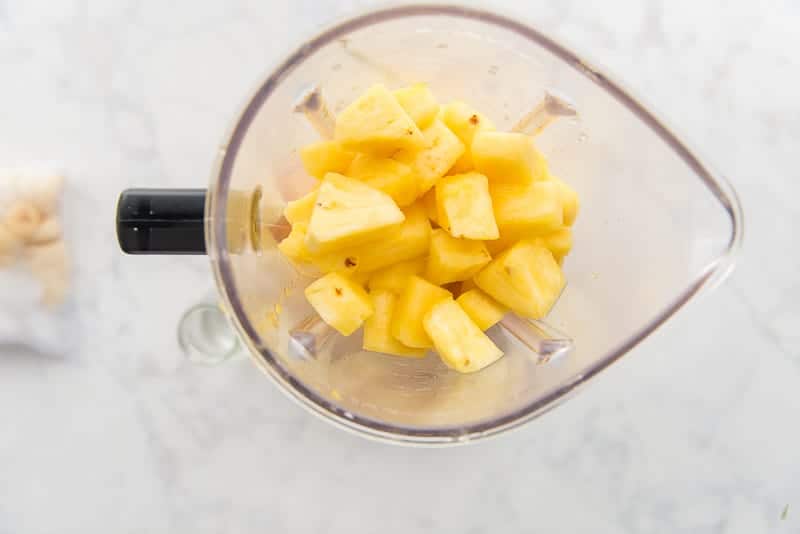 Frozen or chilled pineapple chunks are placed in the blender