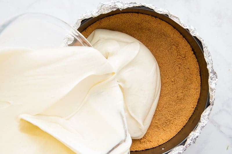 Classic Cheesecake batter is poured into the baked graham cracker crust