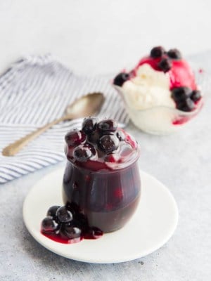 A jar of Blueberry Topping on a white plate