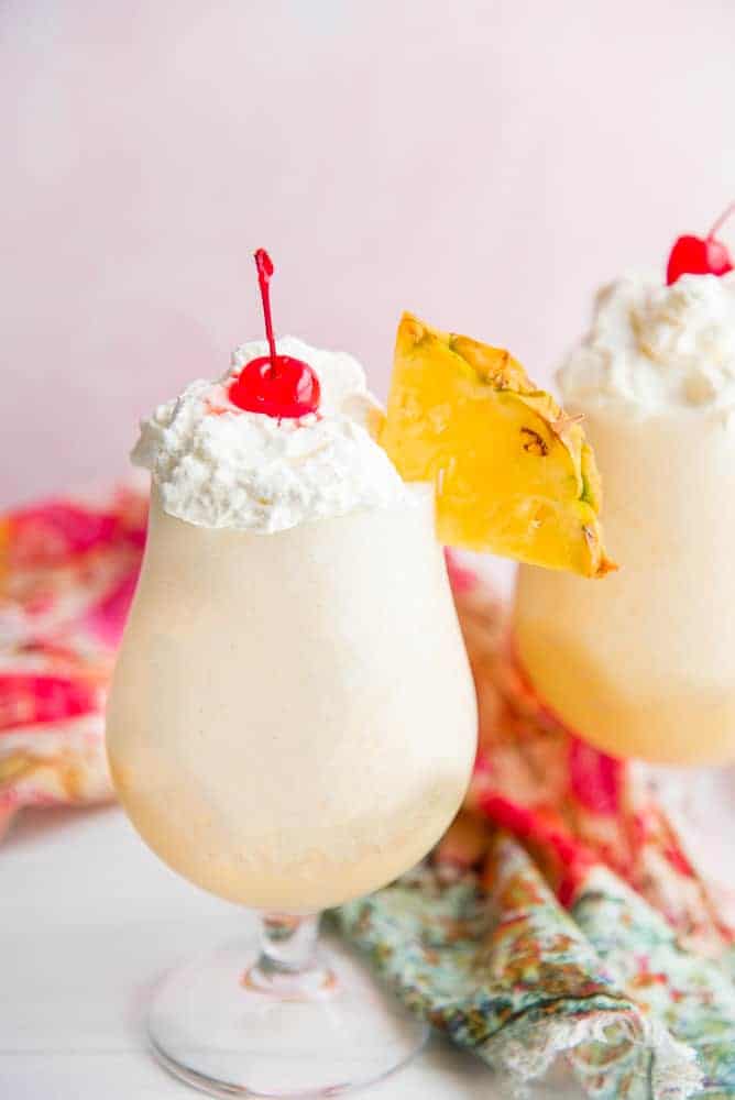 One glass of Piña Coladas with a colorful napkin nearby