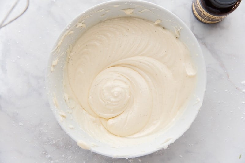 The finished Cream Cheese Icing is in a white mixing bowl