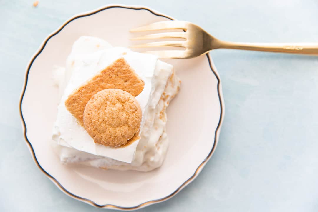 An overhead image of a white, gold-rimmed plate with a portion of Homemade Banana Pudding on it. A gold fork rests on the plate
