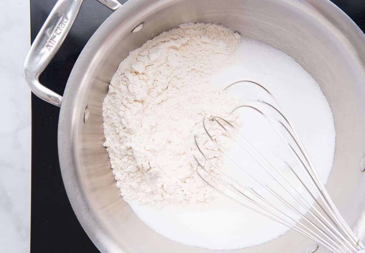The flour and sugar and salt are whisked together in a stainless steel pot
