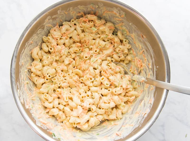 The final mixed Macaroni Salad is in a large metal bowl with a metal spoon.