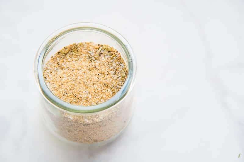 A horizontal image of a glass jar willed with Adobo All-Purpose Seasoning Blend