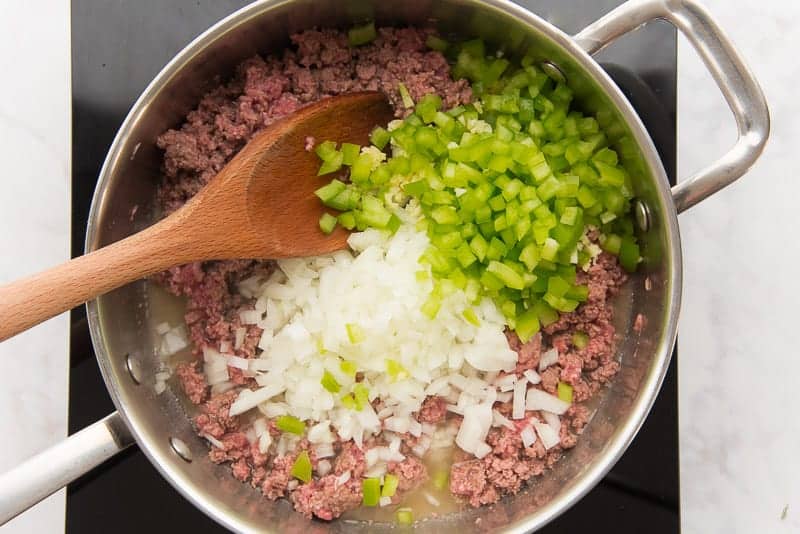 Diced onion, green pepper, and garlic are added to the ground beef
