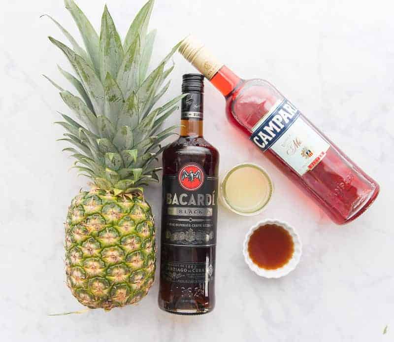 Pineapple, black rum, Campari, lime juice, and chipotle simple syrup are the ingredients used to make a Jungle Bird Cocktail